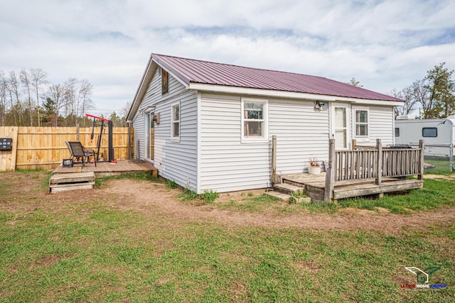 5192 Apache Trl, Harrison, MI 48625 - rear view of property featuring fence, metal roof, a yard, and a deck