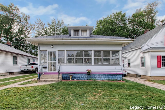 bungalow-style house with a sunroom and a front yard