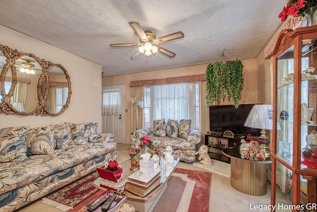 living area featuring a ceiling fan, a textured ceiling, and carpet flooring