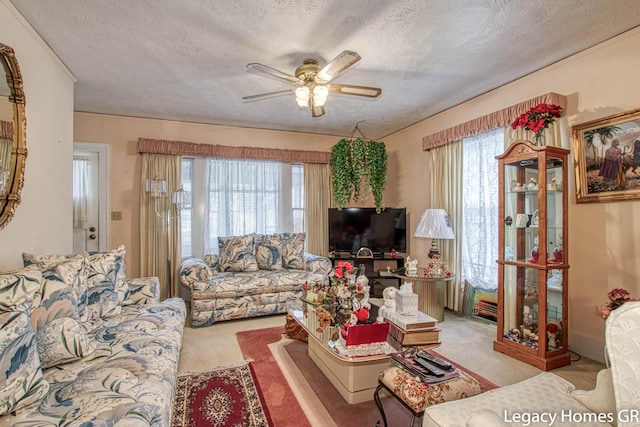 living room featuring a ceiling fan, a textured ceiling, and light colored carpet