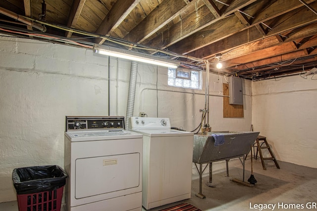 laundry area featuring laundry area, a sink, electric panel, and washer and dryer