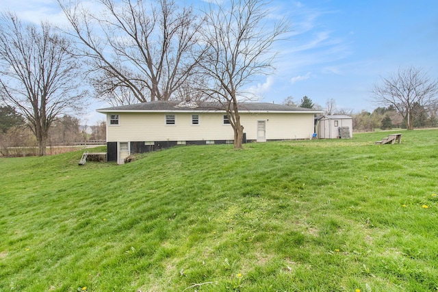 back of house with an outdoor structure, a yard, and a storage shed