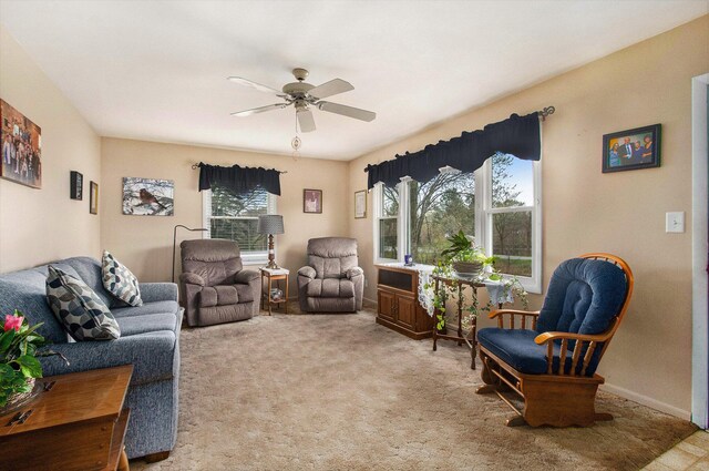 carpeted living area with a ceiling fan