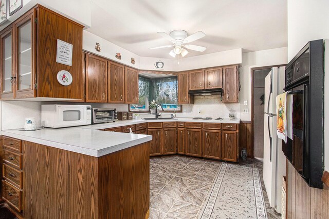 kitchen featuring a peninsula, a sink, white appliances, and light countertops