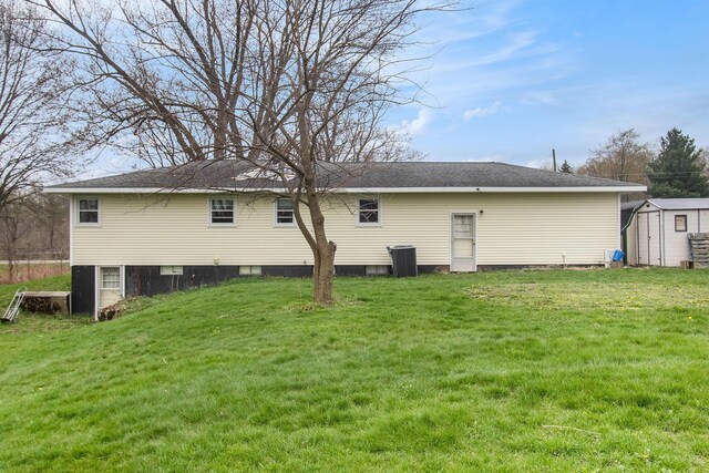 back of property featuring an outbuilding, a yard, and a storage unit