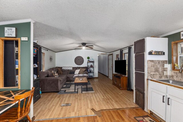 16788 David Ct, Mecosta, MI 49332 - living area featuring a ceiling fan, crown molding, a textured ceiling, light wood-type flooring, and lofted ceiling