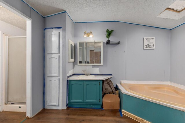16788 David Ct, Mecosta, MI 49332 - full bath featuring a garden tub, wood finished floors, a textured ceiling, and a stall shower