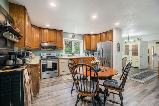 53746 Stevens Ln, Three Rivers, MI 49093 - kitchen featuring appliances with stainless steel finishes, brown cabinetry, light wood-style flooring, light countertops, and recessed lighting