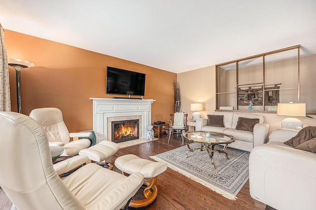 living room featuring a fireplace with flush hearth and wood finished floors