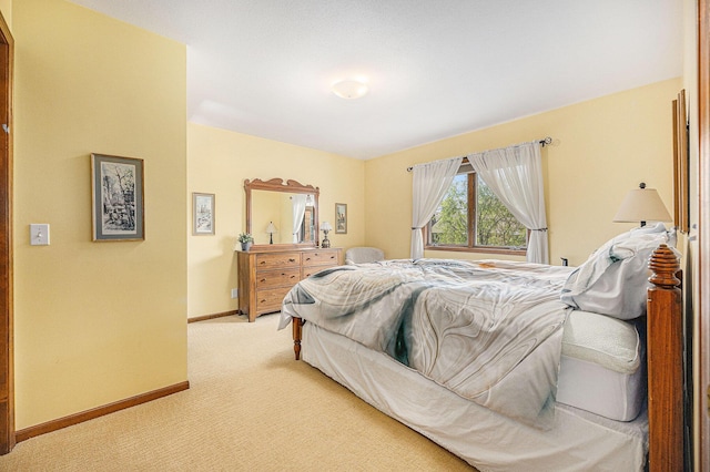 bedroom with light carpet and baseboards