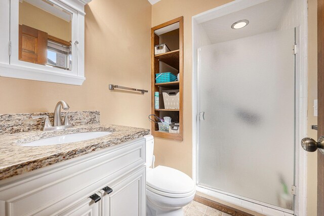 full bathroom with tile patterned floors, vanity, toilet, and a stall shower