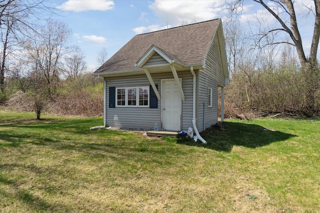 exterior space with roof with shingles and a front yard