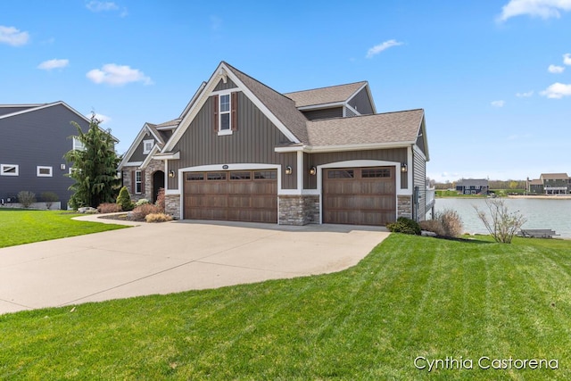11325 Wake Dr, Allendale, MI 49401 - craftsman house with a front lawn, concrete driveway, a water view, a shingled roof, and stone siding