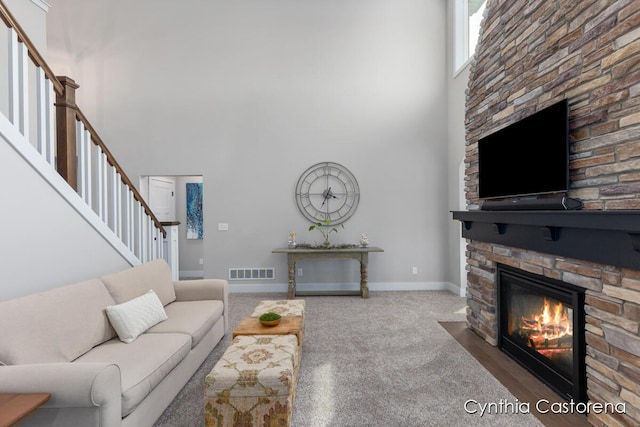 11325 Wake Dr, Allendale, MI 49401 - living area featuring visible vents, carpet floors, stairs, a towering ceiling, and a fireplace