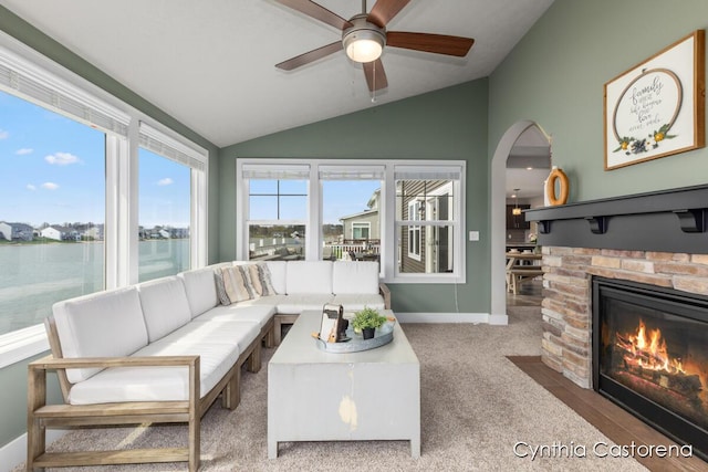11325 Wake Dr, Allendale, MI 49401 - carpeted living area featuring a fireplace with flush hearth, baseboards, a ceiling fan, and lofted ceiling