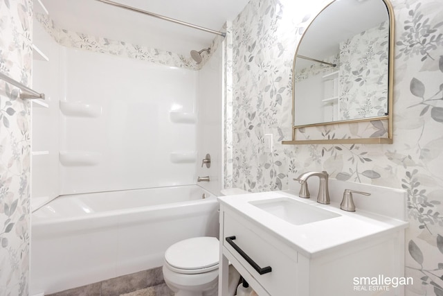 bathroom featuring vanity, washtub / shower combination, toilet, and wallpapered walls