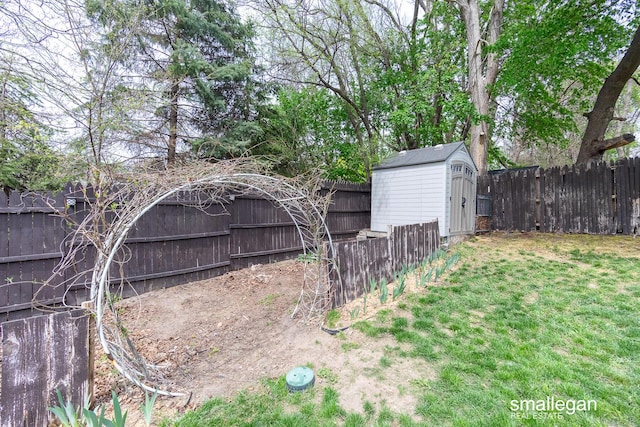 view of yard with an outbuilding, a fenced backyard, and a shed