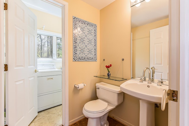 285 Mulholland Ave, Ann Arbor, MI 48103 - bathroom featuring toilet, a sink, washer / dryer, and baseboards