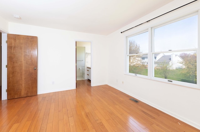 3126 Fairhaven Ct, Ann Arbor, MI 48105 - unfurnished bedroom with connected bathroom, baseboards, visible vents, and light wood finished floors