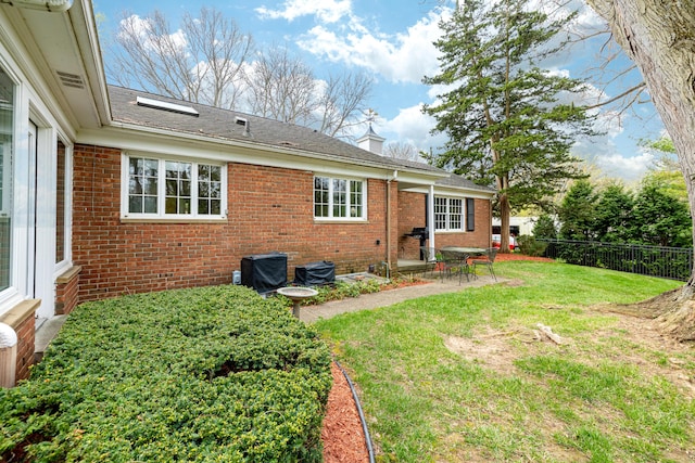 1060 Chestnut St, Ann Arbor, MI 48104 - back of house featuring a patio, brick siding, fence, and a lawn