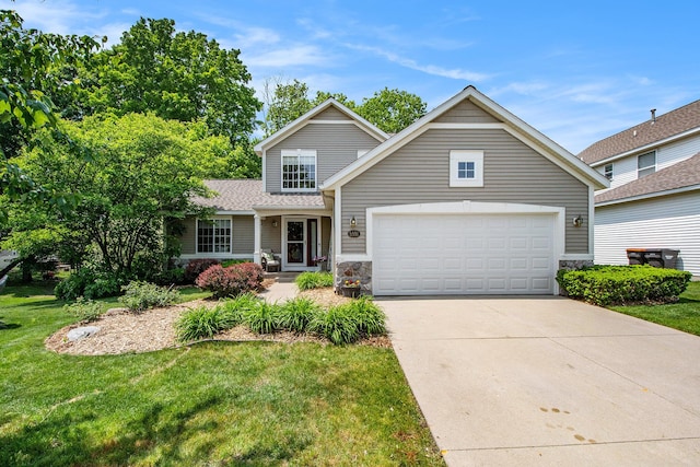 5591 E Grove Dr SE, Grand Rapids, MI 49512 - traditional-style home with driveway, a front yard, an attached garage, and stone siding