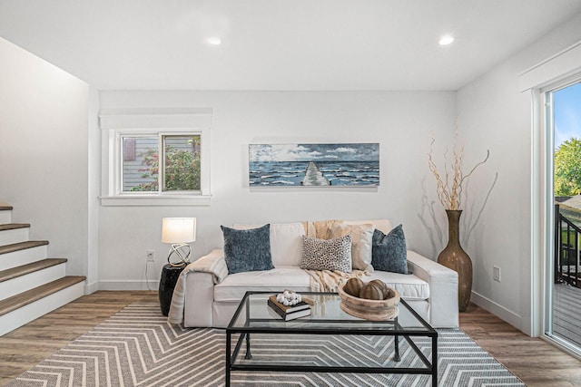 living area featuring baseboards, recessed lighting, wood finished floors, and stairs