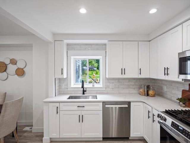 kitchen with recessed lighting, a sink, appliances with stainless steel finishes, and decorative backsplash