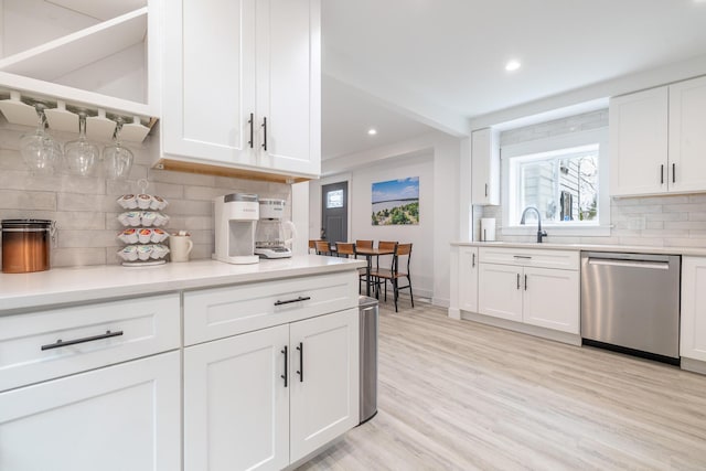 kitchen with recessed lighting, stainless steel dishwasher, white cabinets, and backsplash
