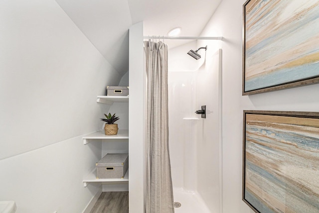 bathroom with a stall shower and wood finished floors