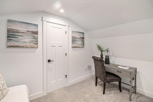 office area featuring lofted ceiling, visible vents, light carpet, and baseboards