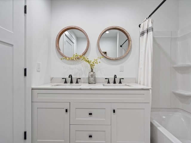 full bath with double vanity, a sink, and shower / bath combo