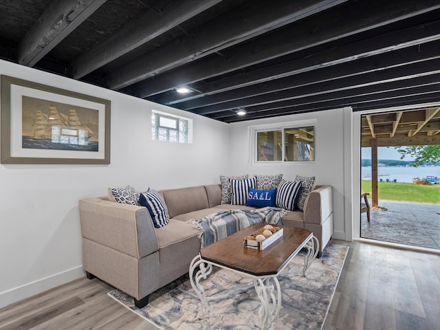 living area featuring baseboards, a water view, and light wood-style flooring
