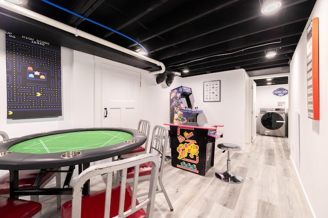 playroom with washing machine and clothes dryer and wood finished floors