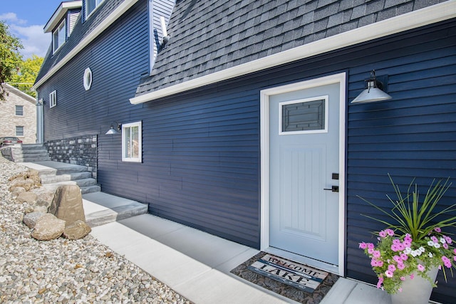 doorway to property featuring a shingled roof