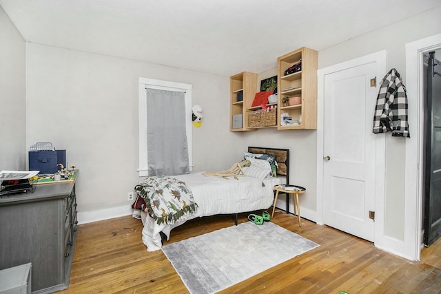bedroom with wood finished floors and baseboards
