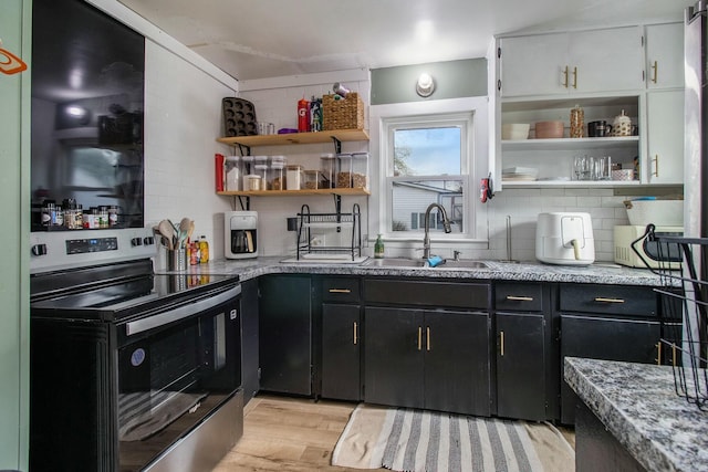 kitchen with light wood-style flooring, a sink, dark cabinetry, open shelves, and electric stove