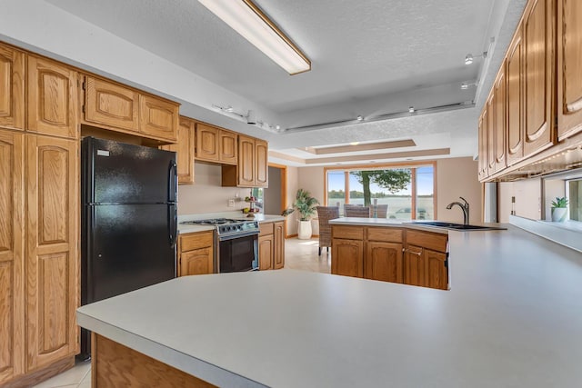 150 Hyde Rd, Clarklake, MI 49234 - kitchen featuring range with gas stovetop, a sink, freestanding refrigerator, a peninsula, and light tile patterned floors