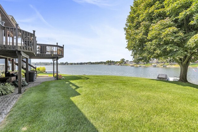 view of yard with a deck with water view and stairway
