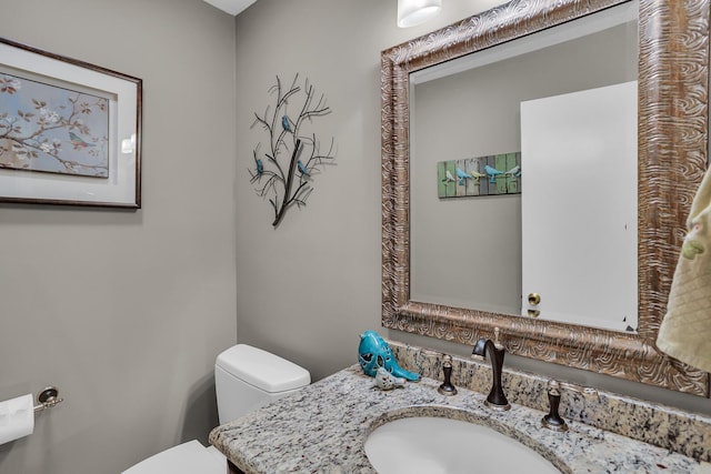 half bath featuring vanity and toilet