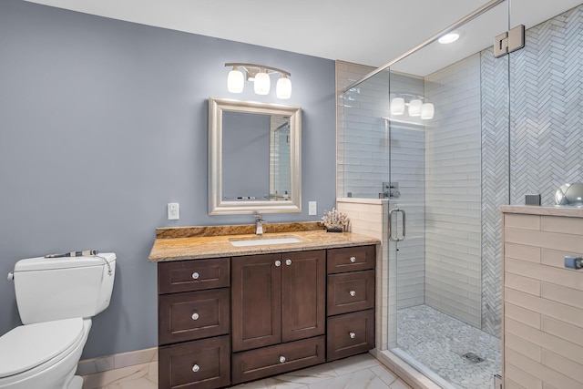 bathroom featuring vanity, toilet, marble finish floor, baseboards, and a shower stall