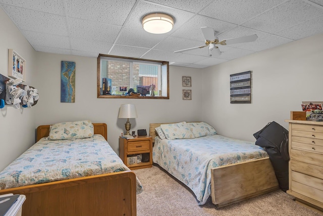 bedroom featuring a ceiling fan, a paneled ceiling, and light carpet