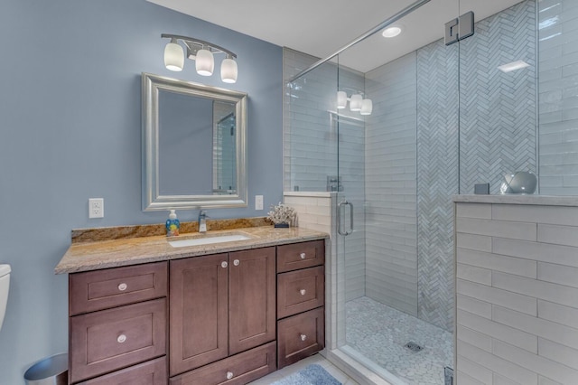 bathroom featuring vanity, toilet, and a shower stall