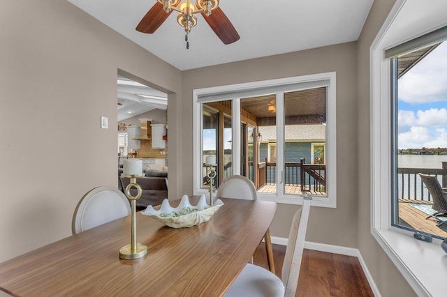 dining room with a ceiling fan, baseboards, vaulted ceiling, and wood finished floors