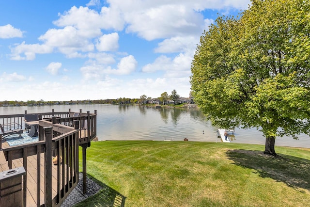 dock area with a lawn and a water view