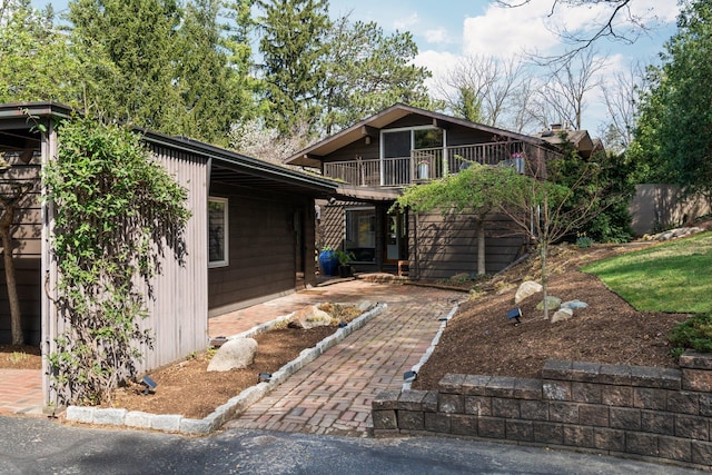 view of front of property featuring a balcony and a patio area