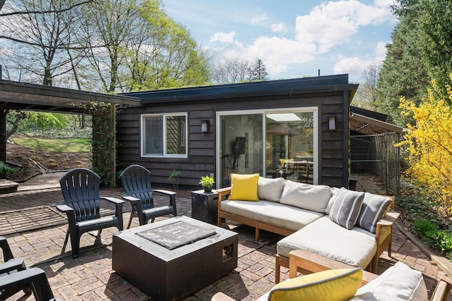 view of patio with an outdoor living space with a fire pit