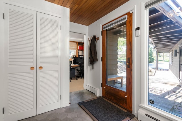 doorway with dark tile patterned floors, a baseboard heating unit, and wooden ceiling