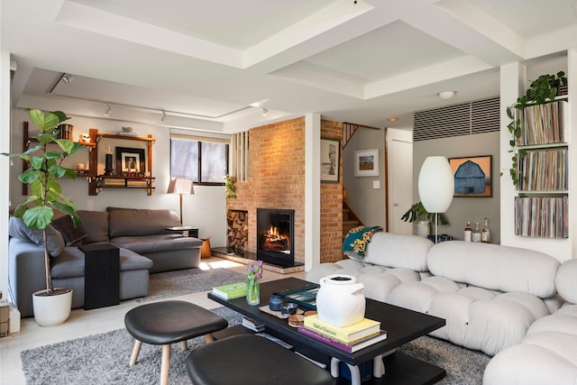 living room with coffered ceiling, a brick fireplace, and beam ceiling