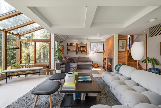living room with plenty of natural light, coffered ceiling, and a large fireplace
