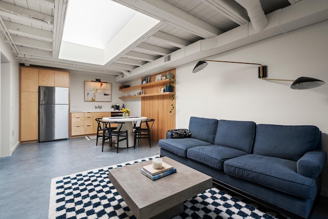 living area with finished concrete flooring, beam ceiling, and visible vents